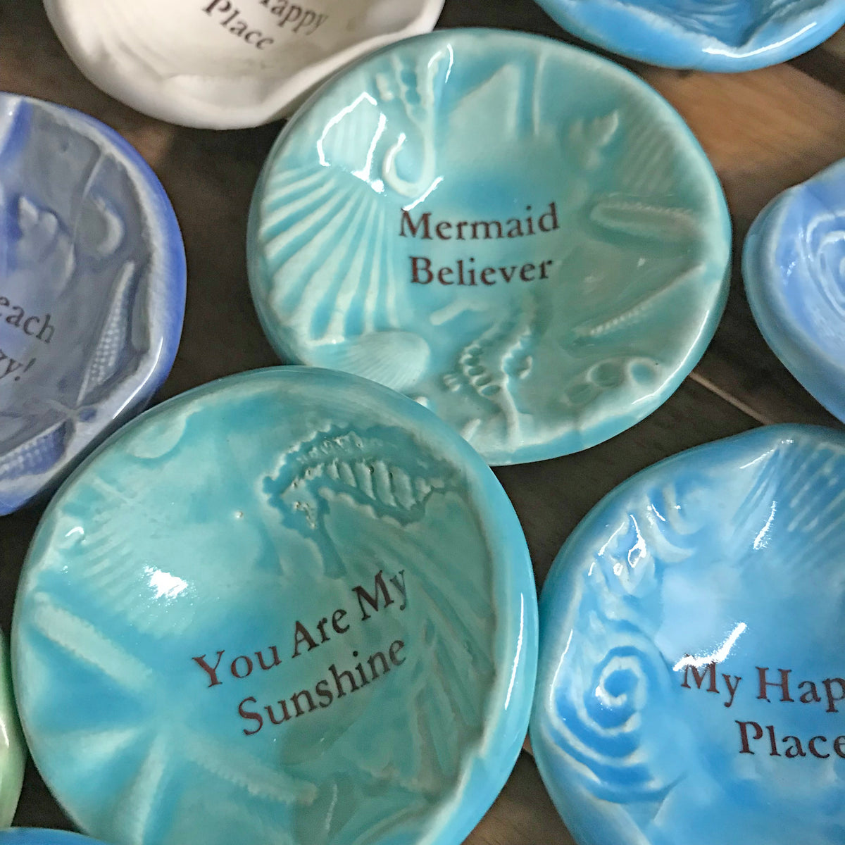 Giving Bowls with shells, starfish and seahorse designs. come in 10 words or phrases including &quot;Mermaid Believer.&quot; A 