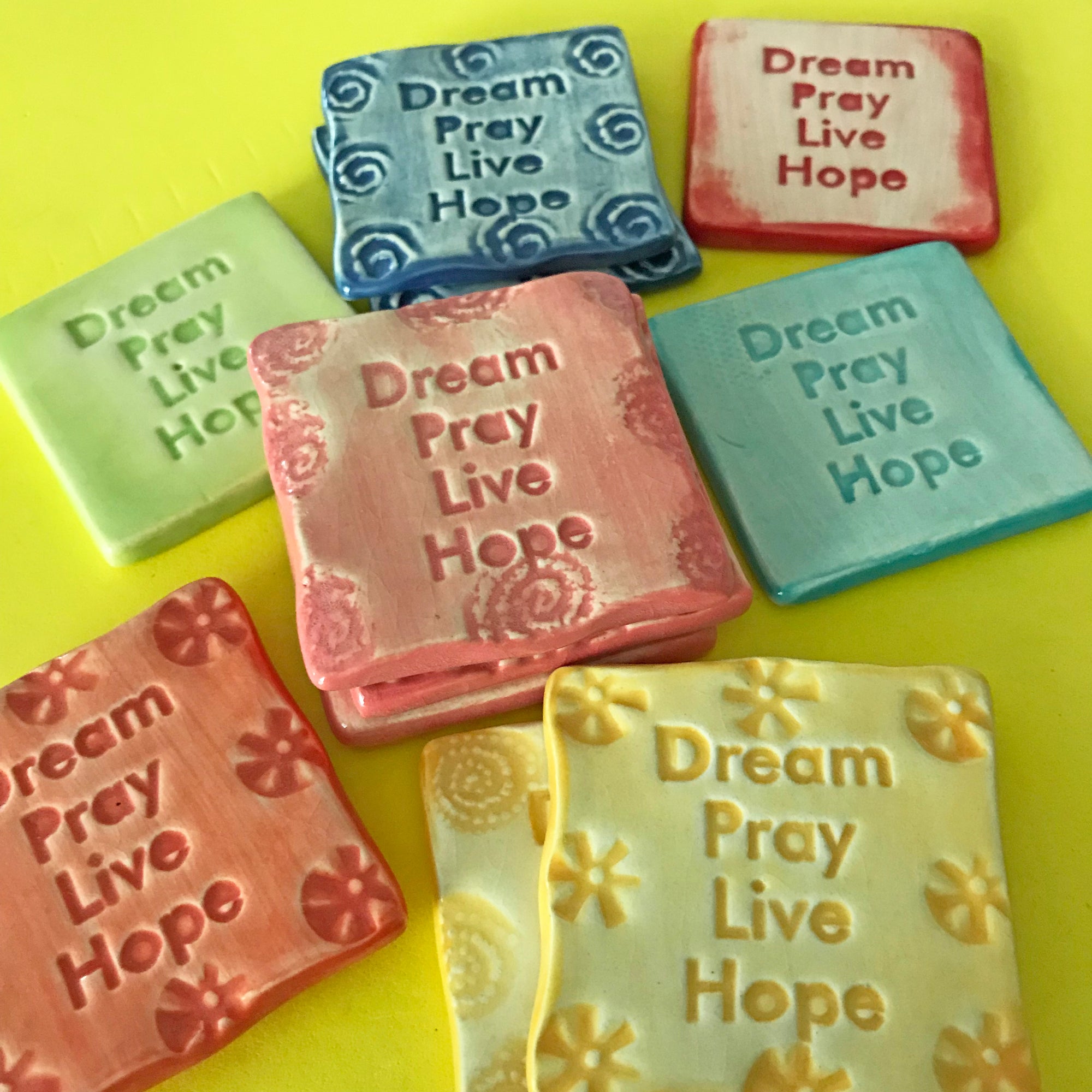 A magnet offering a message of support: "Dream, Pray, Live, Hope."  Handmade ceramic.