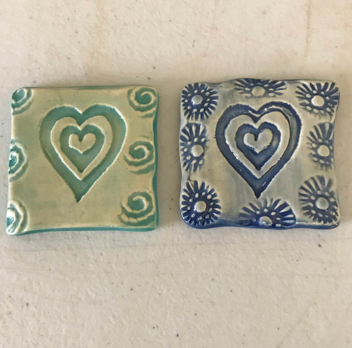 Magnets decorated with a simple heart design.  Handmade and each varies.