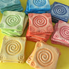 Spiral Sun motif pressed into soft clay to become our unique, colorful and affordable refrigerator magnets.