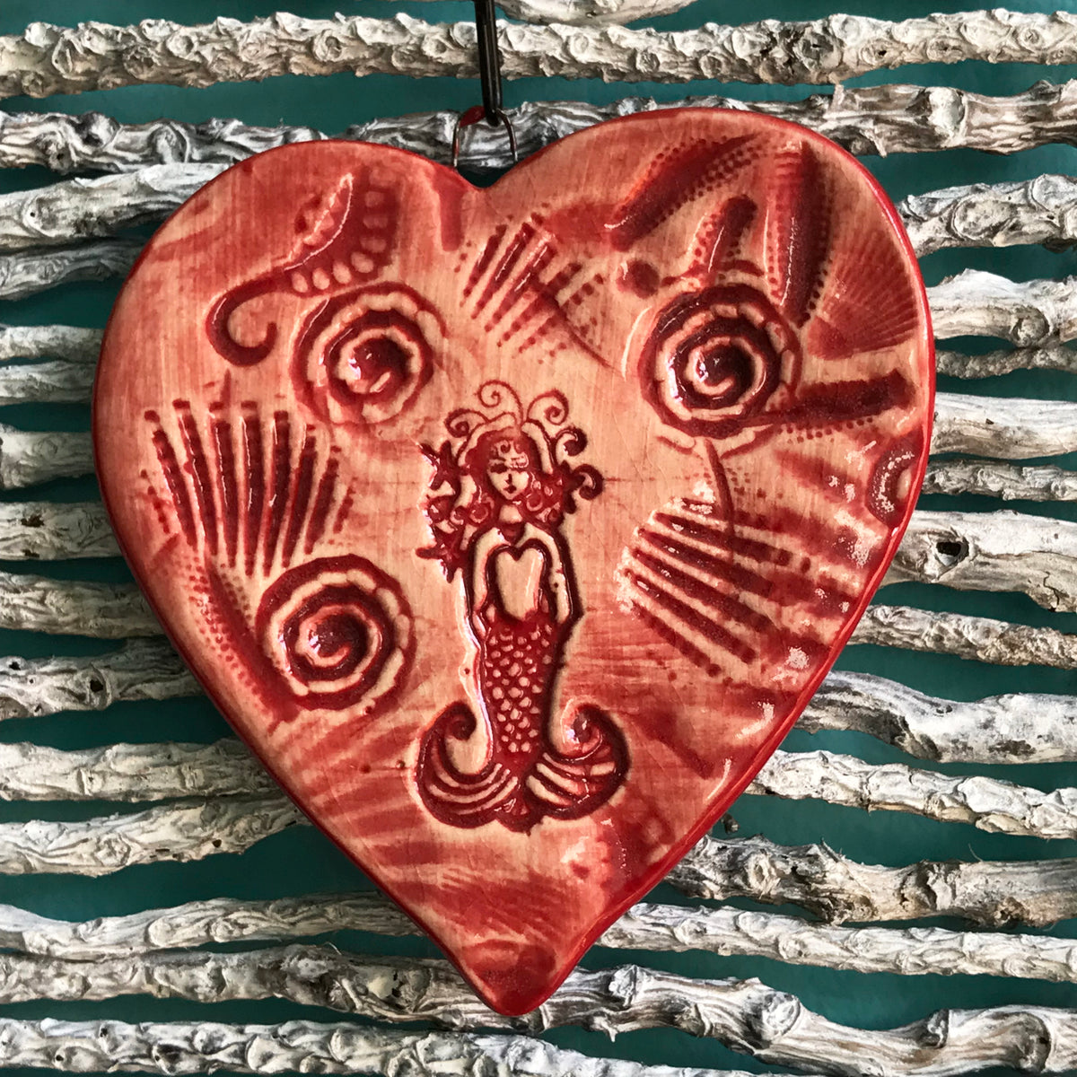 Unusual handcrafted holiday ornament of a mermaid surrounded by sea life.  Glazed in bright red.  