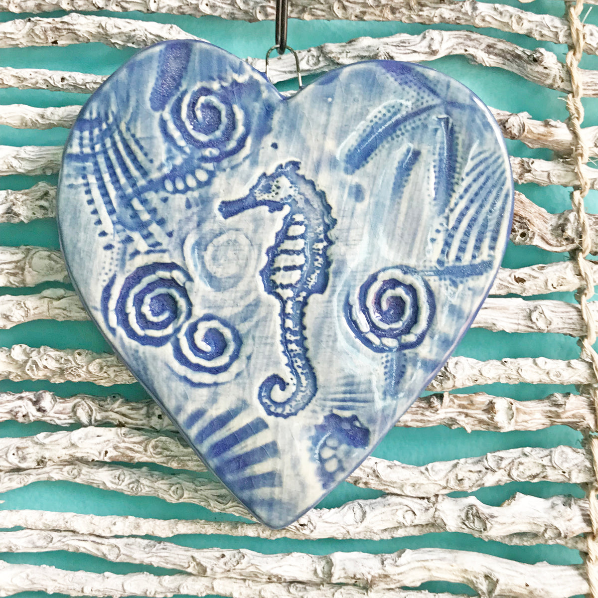 Beautiful handmade Sea Horse Ornament.  Has detailed texture of natural shells and our sea horse drawing is placed in the middle.  Glazed in delft blue. 