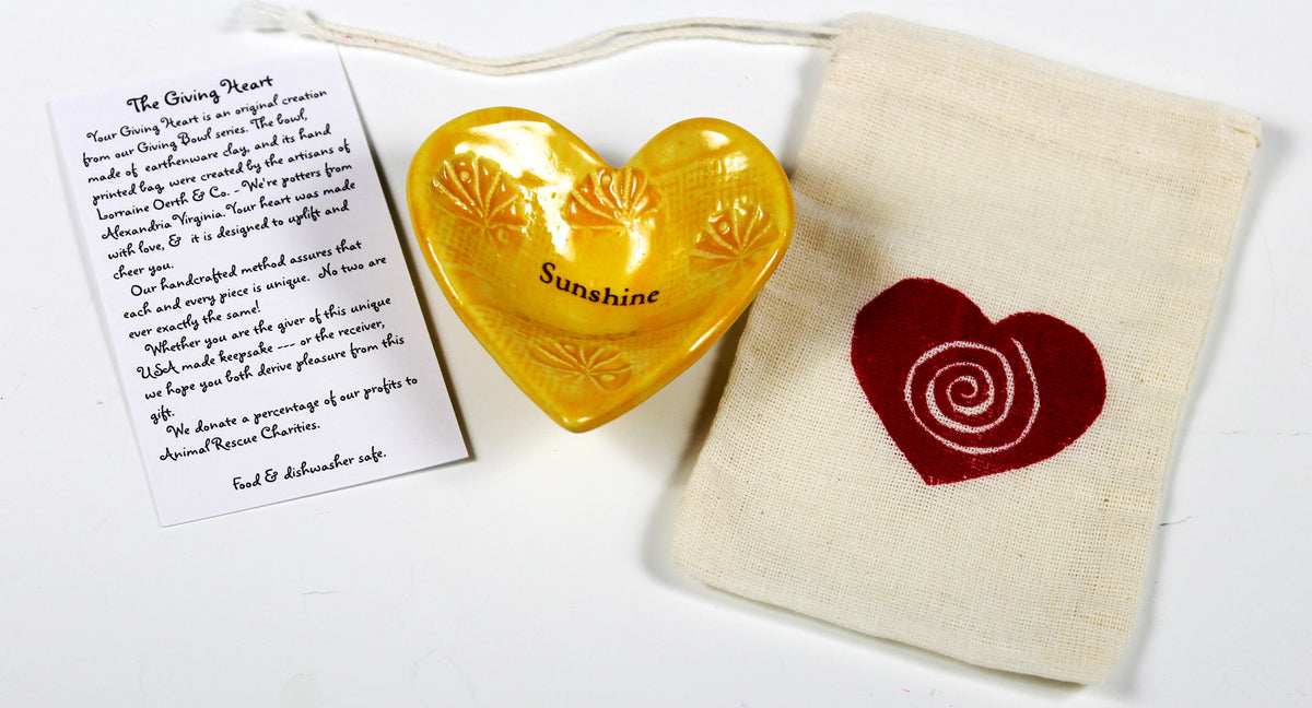 Lorraine Oerth Giving Heart with the word Sunshine glazed in a cheerful yellow color.  item is crafted by hand.  
