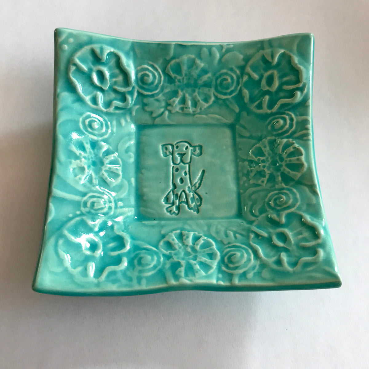 Turquoise glaze enhances dog design on small dish handmade by Lorraine Oerth.