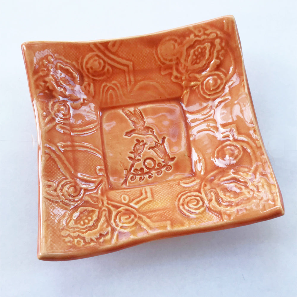 Lorraine Oerth's original design of hummingbird on handmade pottery dish.
