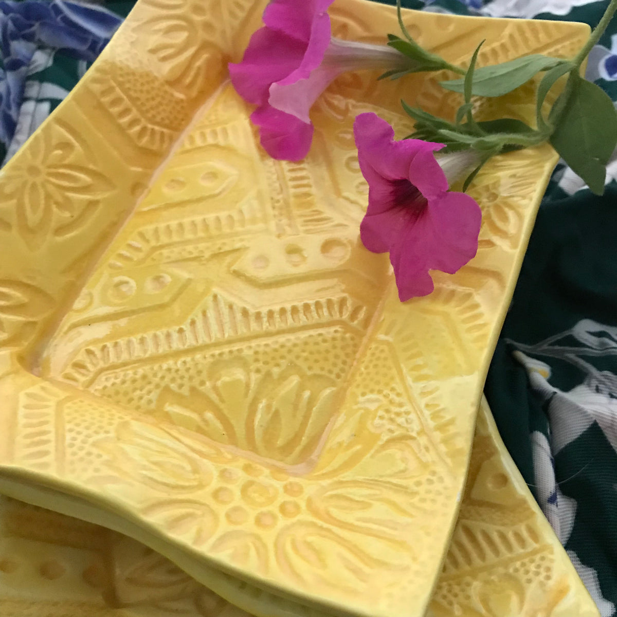 Stunning handmade ceramic tray in yellow glaze shown with magenta flowers. with 